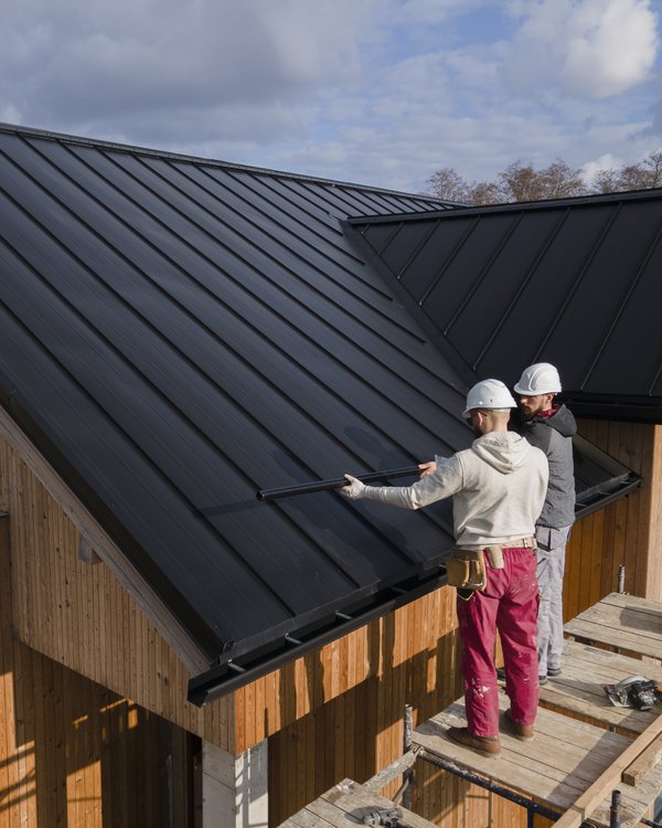 Roofing team installing metal roof